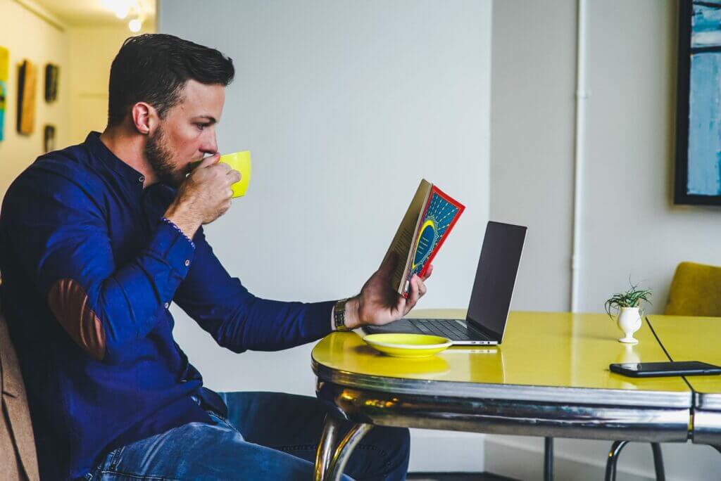 Man drinking coffee while working in an office space for creativity